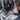 A technician in a dark gray uniform holds a handheld diagnostic device next to a large industrial refrigeration unit with a black compressor and blue pumps.